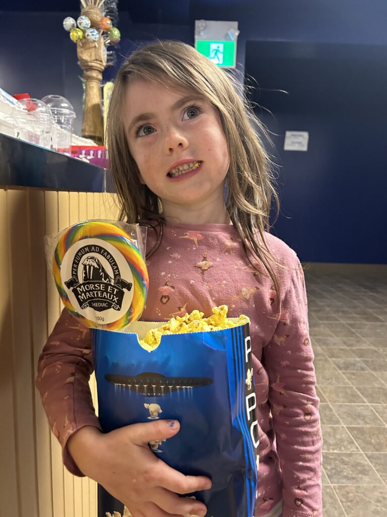 Alice with enjoying a large popcorn at a mega sucker at the Neptune Drive-In Theatre, in Shediac, NB.