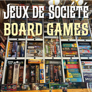 Hundreds of Euro-style board games on a shelf at Bistro Le Moque-Tortue. The Words "board games" are spelled out in large letters above.