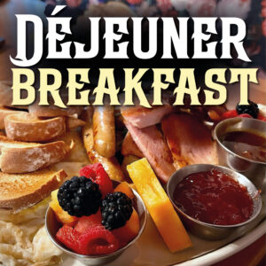 A large plate of breakfast goodies including a mini fruit salad, eggs, toast, sausages, ham, and baked beans. The words "Déjeuner Breakfast" are featured above.