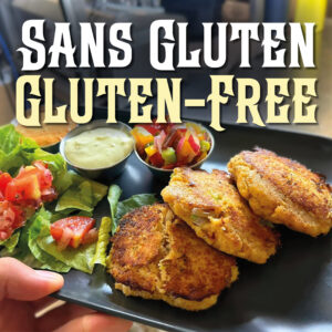 Gluten-free crab cakes with three ramekins of side sauces and a green salad are served at Le Moque-Tortue, in Shediac, NB.