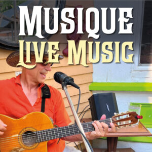 A guitarist with a microphone entertains the crowds on the patio of Le Moque-Tortue